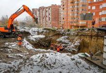 Рабочие засыплют яму в Горском микрорайоне Новосибирска к ноябрю